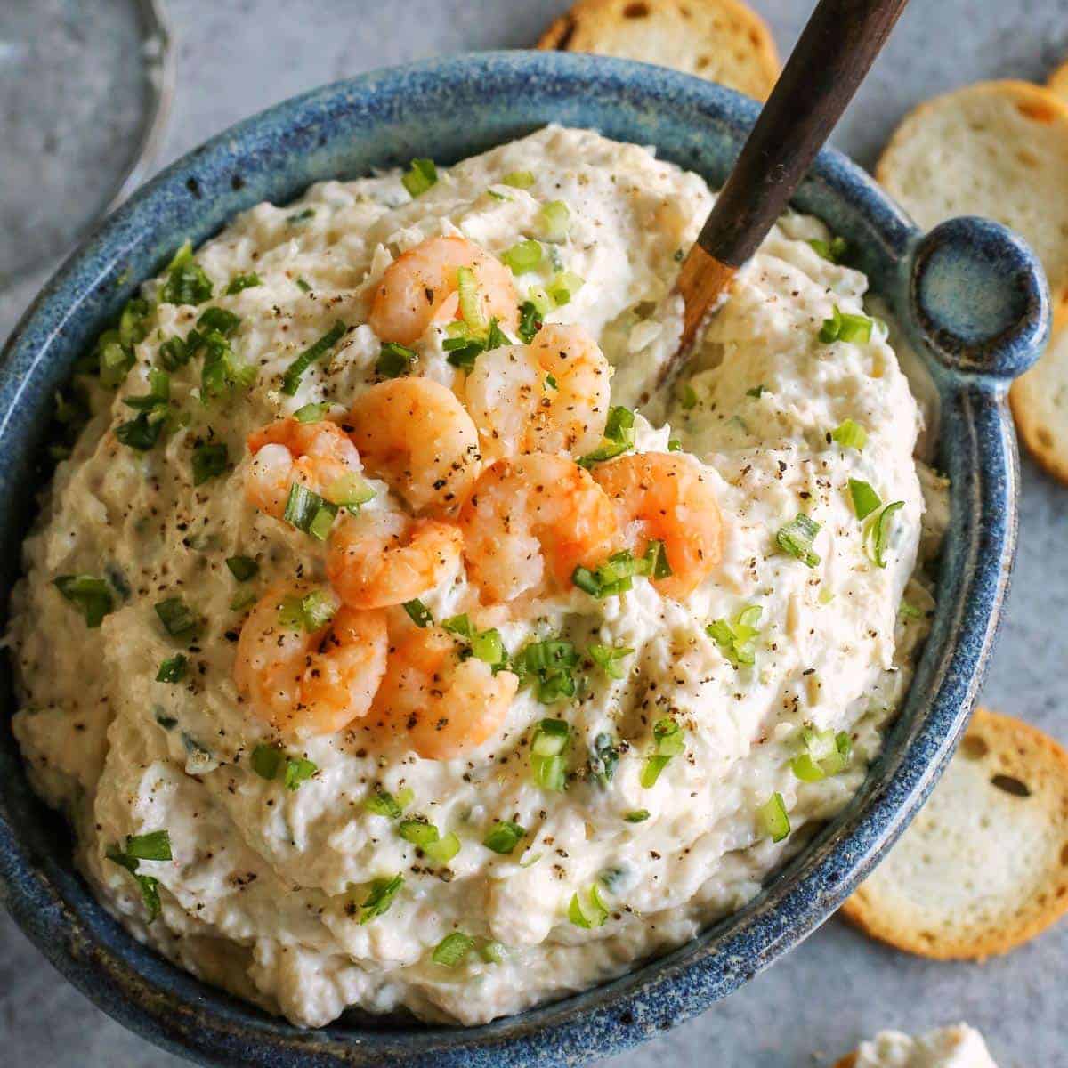 Blue bowl of dip with shrimp.