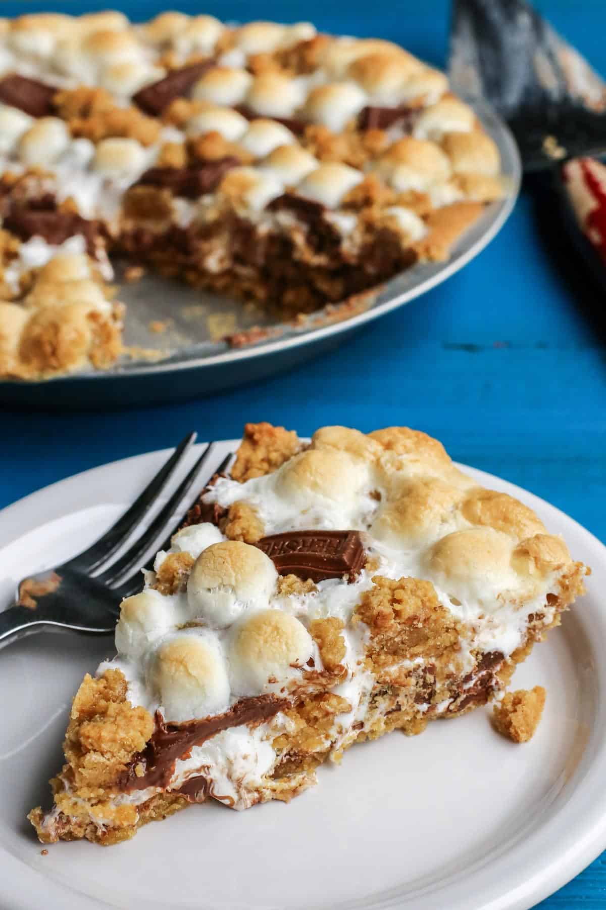 S'mores Pie in the background with a slice on a plate in front