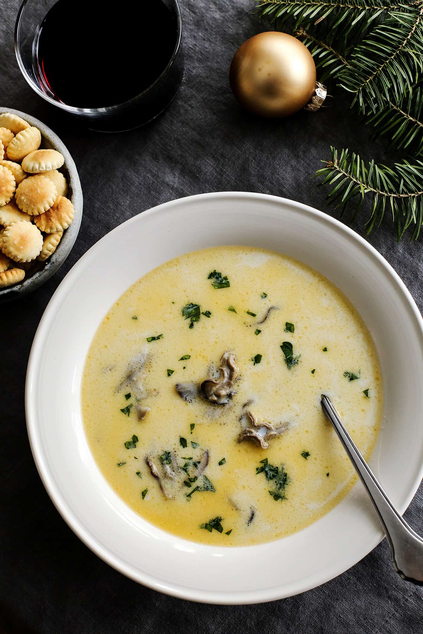 Oyster stew in a white bowl with a silver spoon