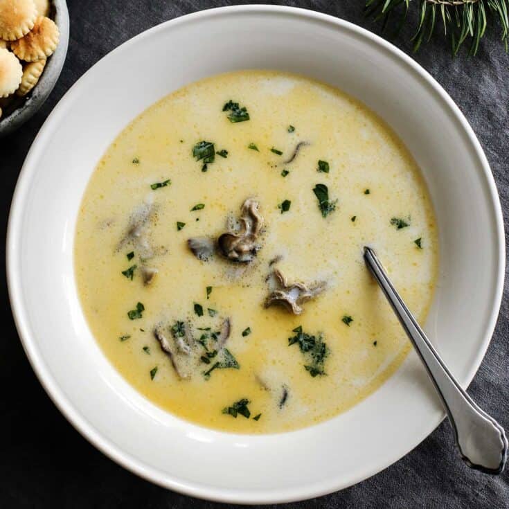 Overhead view of oyster stew in a white bowl