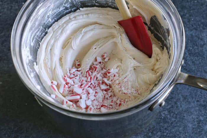 Crushed candy canes being mixed into melted chocolate