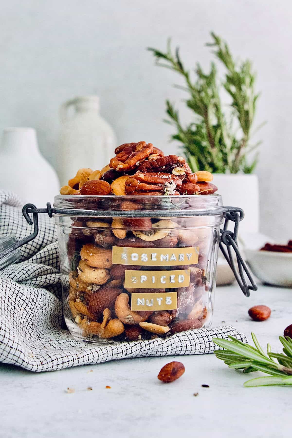 Baked mixed nuts with herbs and spices in a glass jar. 