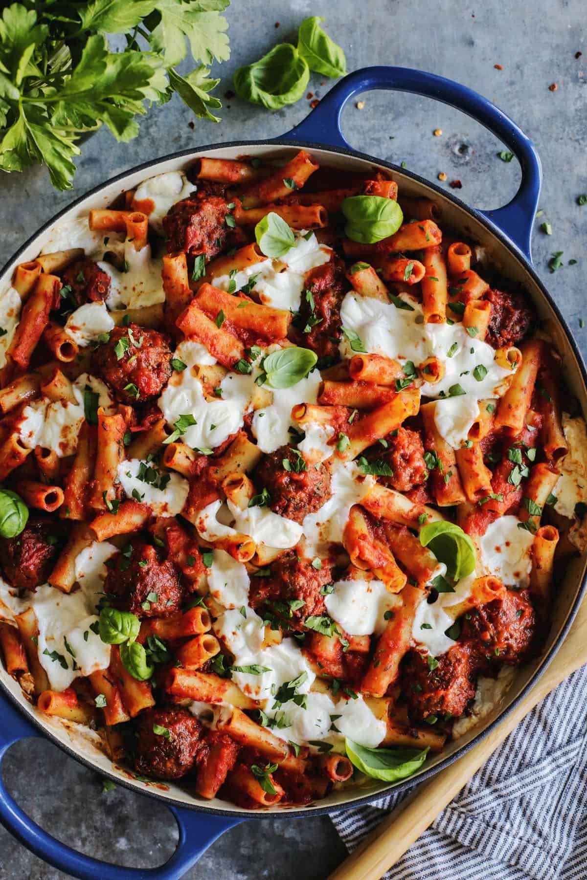 baked pasta with meatballs in a large blue casserole dish