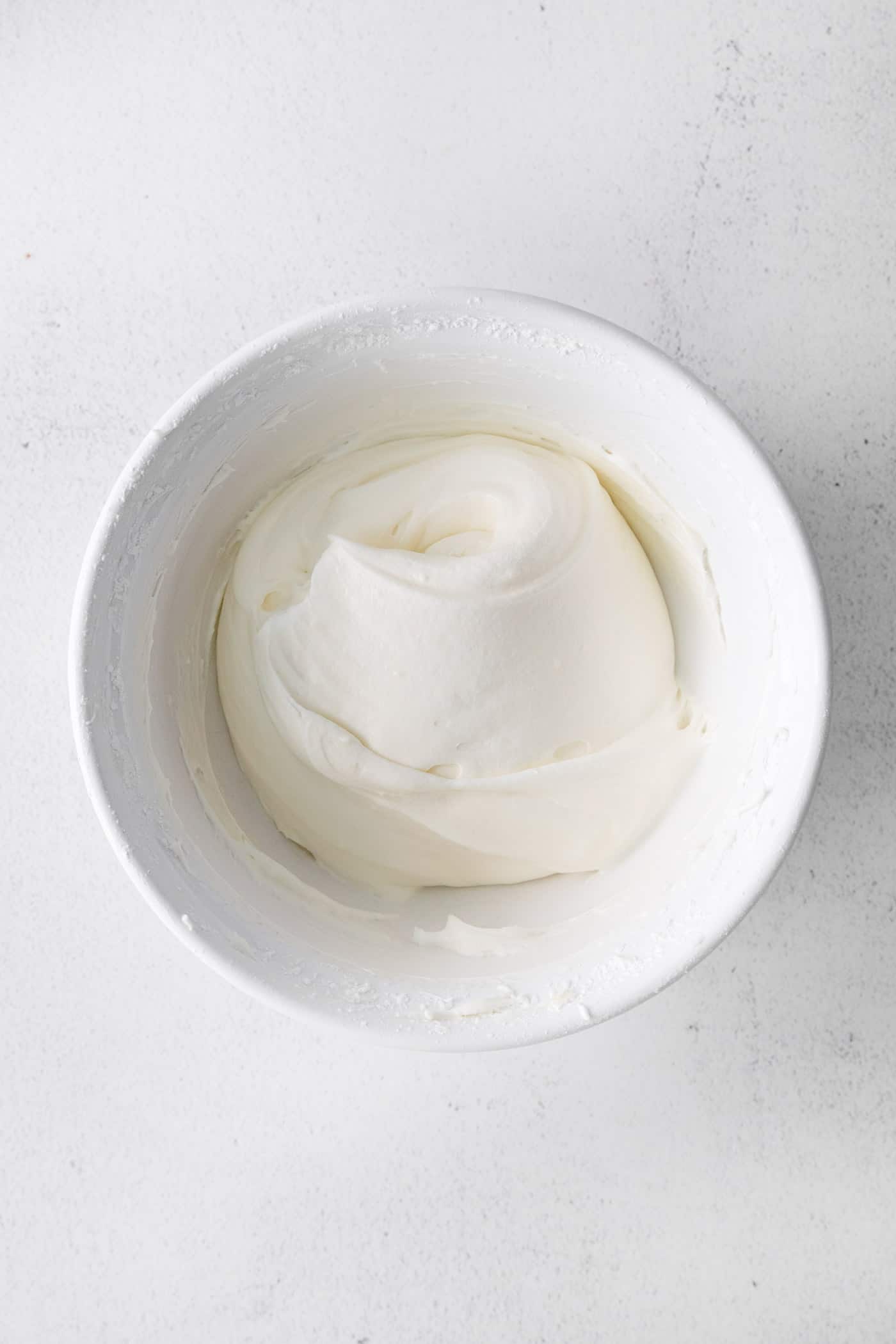 Cream cheese frosting in a white dish