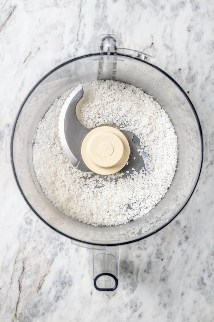 Overhead view of shredded coconut in food processor