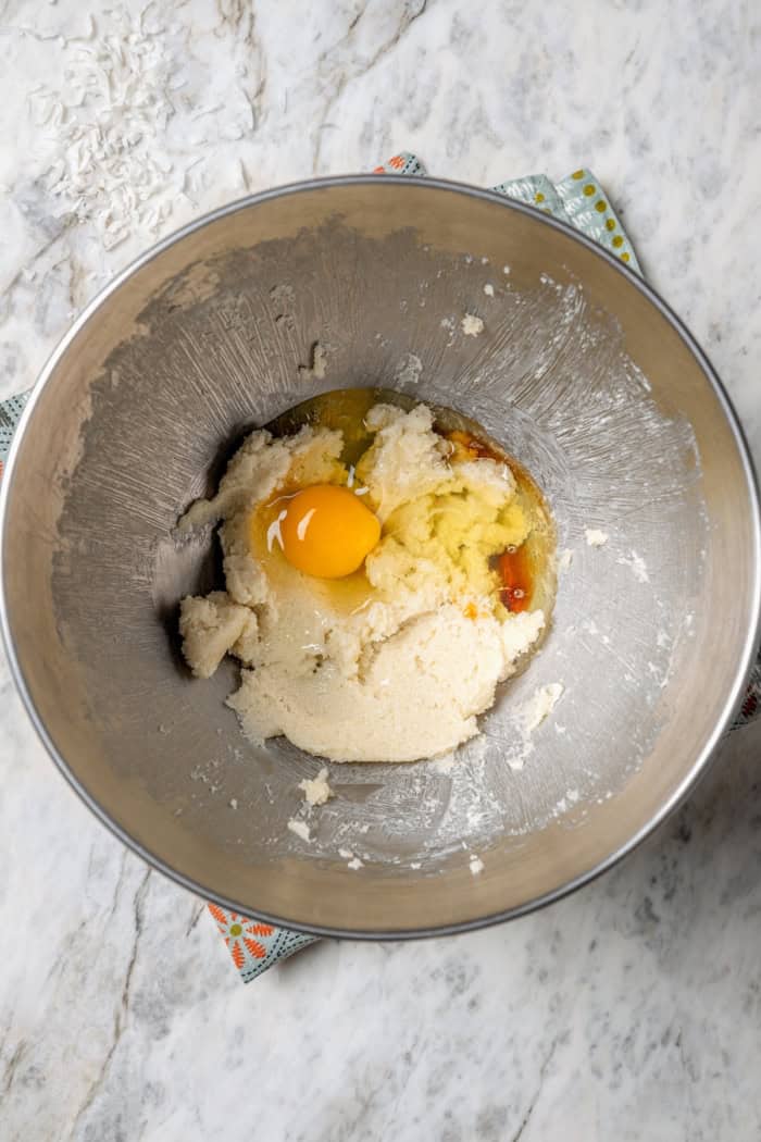 Overhead view of egg added to wet ingredients in bowl