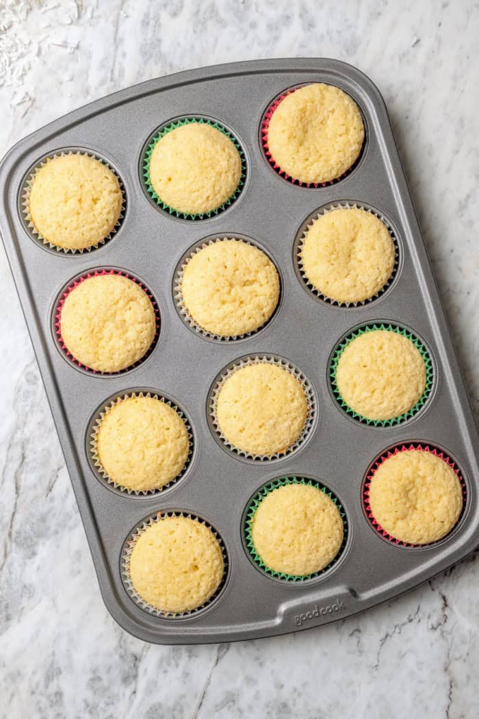Overhead view of coconut cupcakes in pan after baking