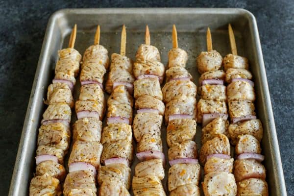 assembled kebabs in a metal pan