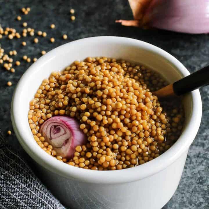 pickled mustard seeds with a wooden spoon