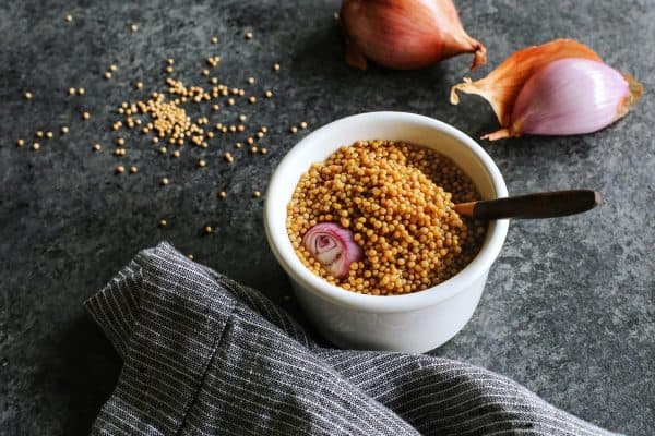 pickled mustard seeds in a white dish