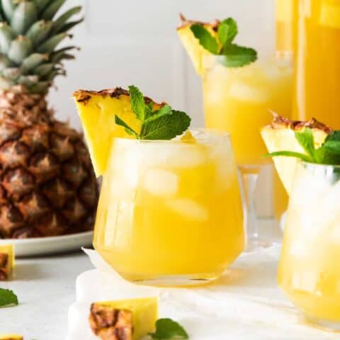 Three pineapple mint julep sangrias garnished with a pineapple slice