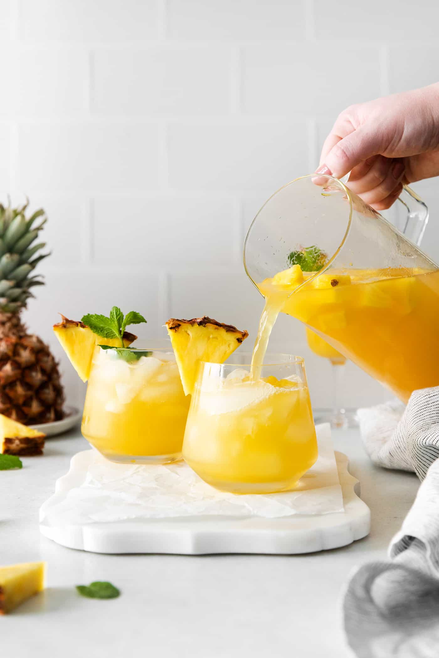 A pitcher of sangria being poured over crushed ice