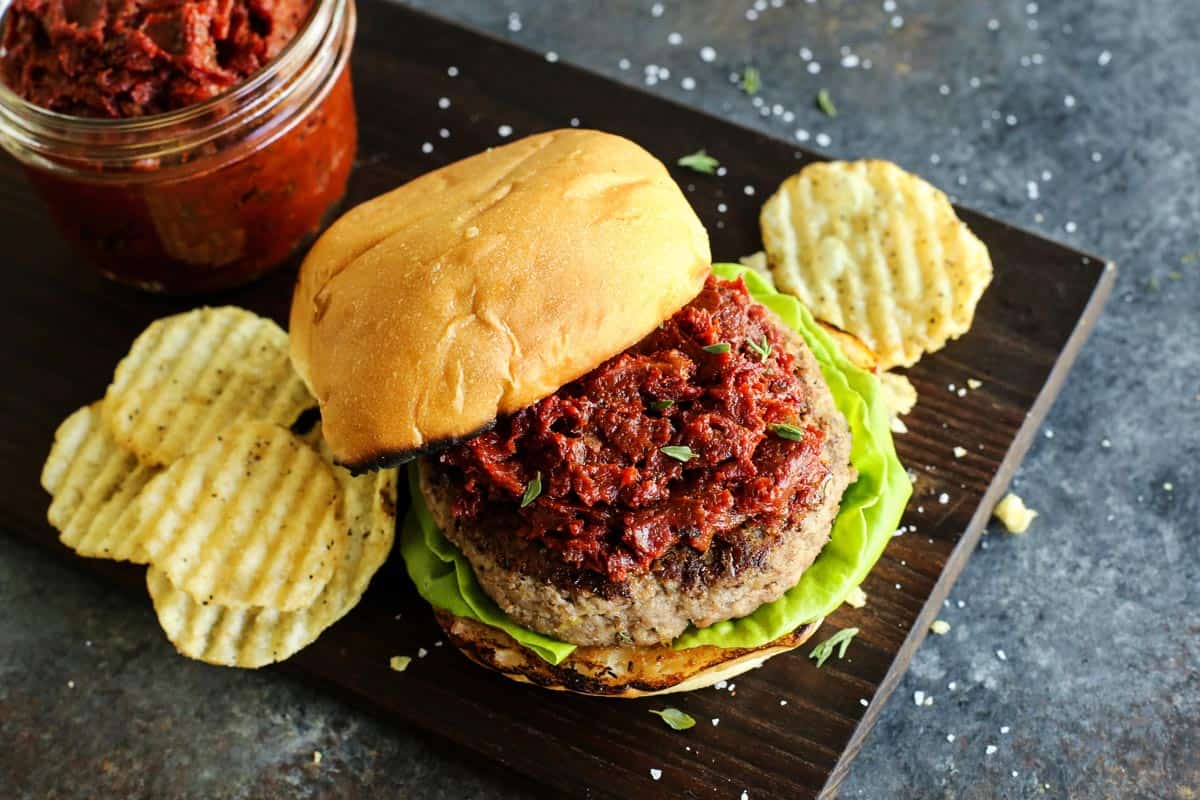 A turkey burger with potato chips on the side.
