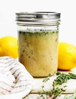 Homemade lemon vinaigrette with fresh herbs in jar