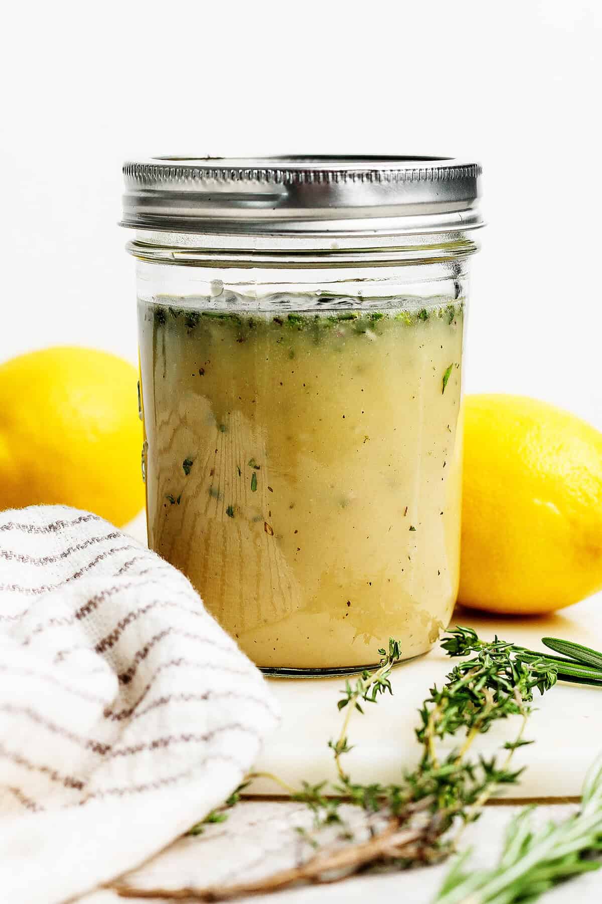 This homemade Lemon Vinaigrette recipe is loaded with bright flavor and fresh herbs. Use it on salads, grilled vegetables, and so much more! Homemade lemon vinaigrette with fresh herbs in jar
