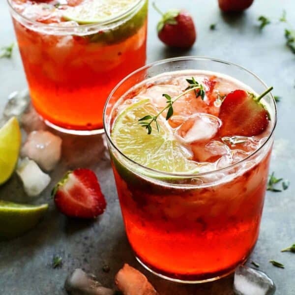 two strawberry gin and tonics in a clear glass