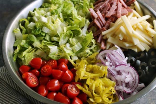 large stainless steel bowl of Italian chopped salad ingredients