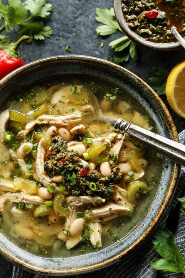 Chicken Chimichurri Soup with White Beans in a pottery bowl with spoon