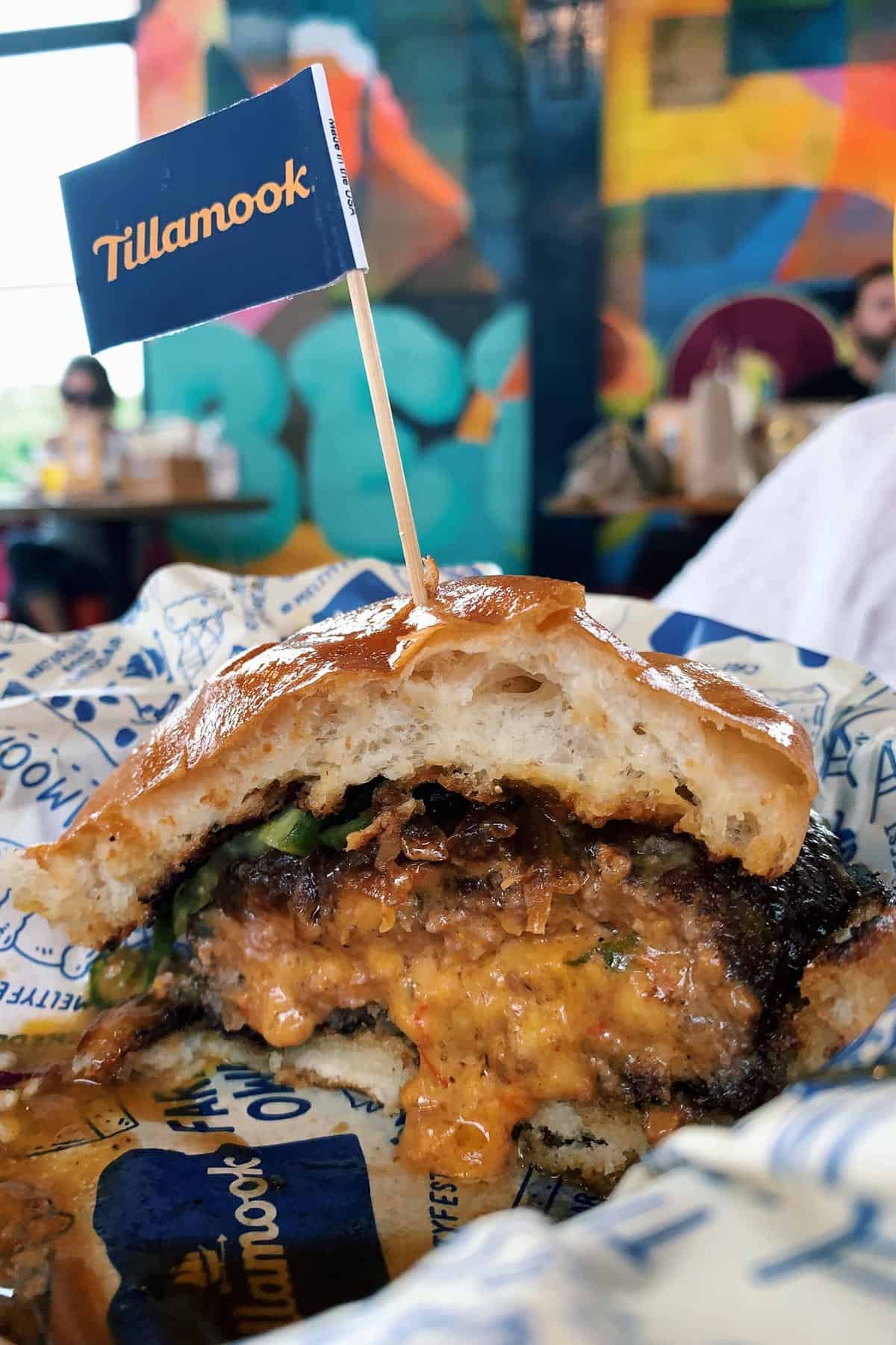 a Juicy Lucy burger cut in half, with pimento cheese sauce oozing out