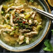 A warm bowl of comforting chimichurri chicken soup with white beans and veggies.