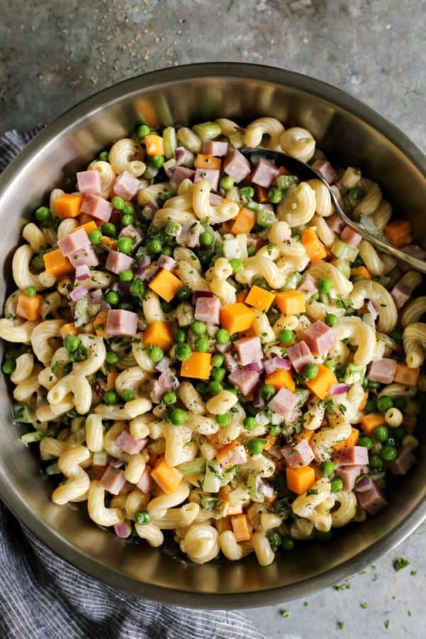 noodle salad with ham and cheese in a stainless steel bowl