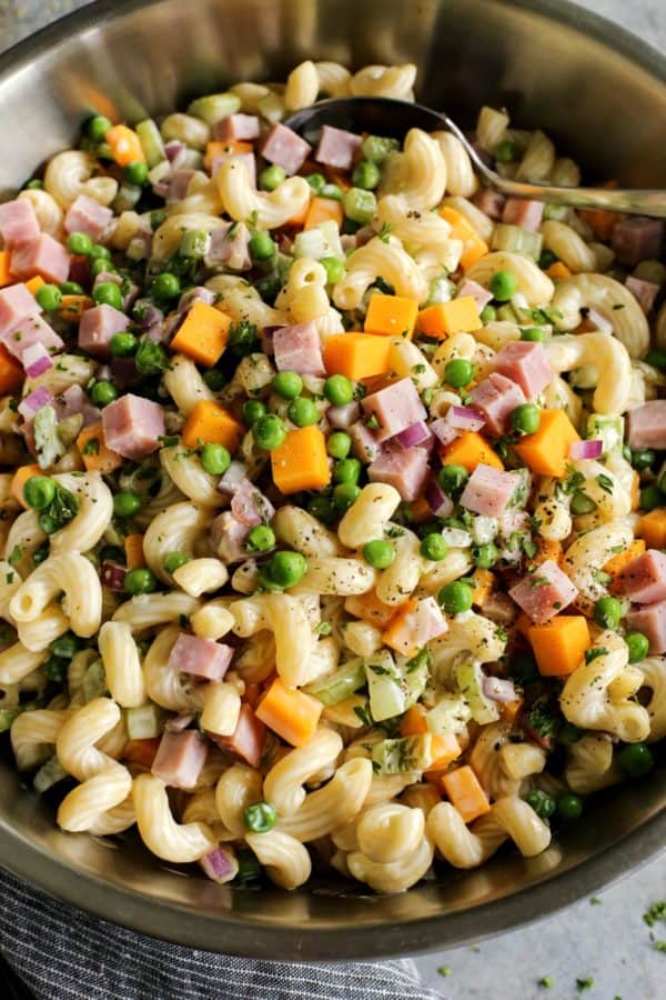 macaroni salad with ham and cheese in a stainless steel bowl