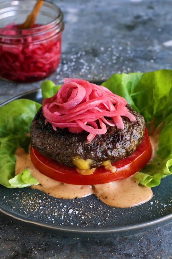 cheese stuffed burger topped with pickled red onions