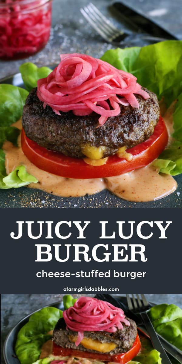 pinterest image of a Juicy Lucy cheese-stuffed burger on a plate, with lettuce, pickled red onions, slice of tomato, and creamy burger sauce