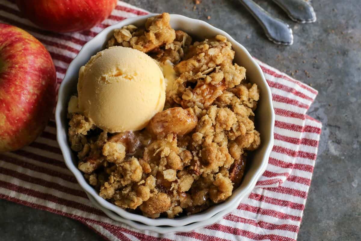 apple dessert in a white dish with a scoop of ice cream