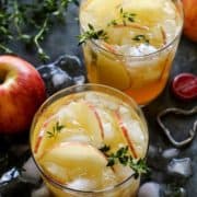 Close-up of my apple cider sangria recipe with ice and a rosemary sprig.
