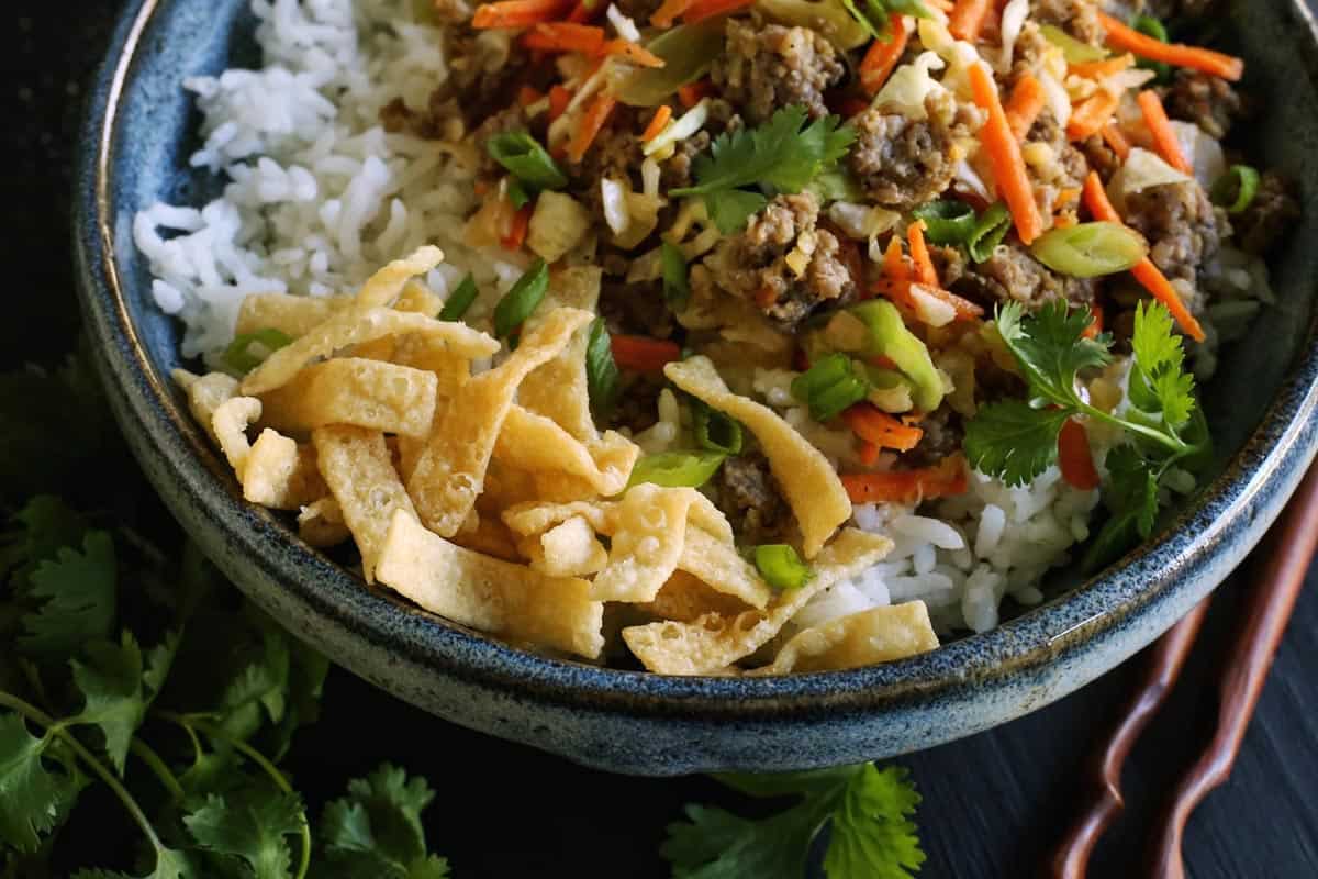 a blue bowl filled with egg roll in a bowl ingredients