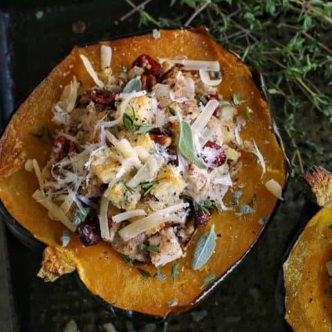 halved acorn squash on pan, stuffed with a turkey and dressing mixture