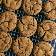 a batch of ginger molasses cookies on a cooling rack