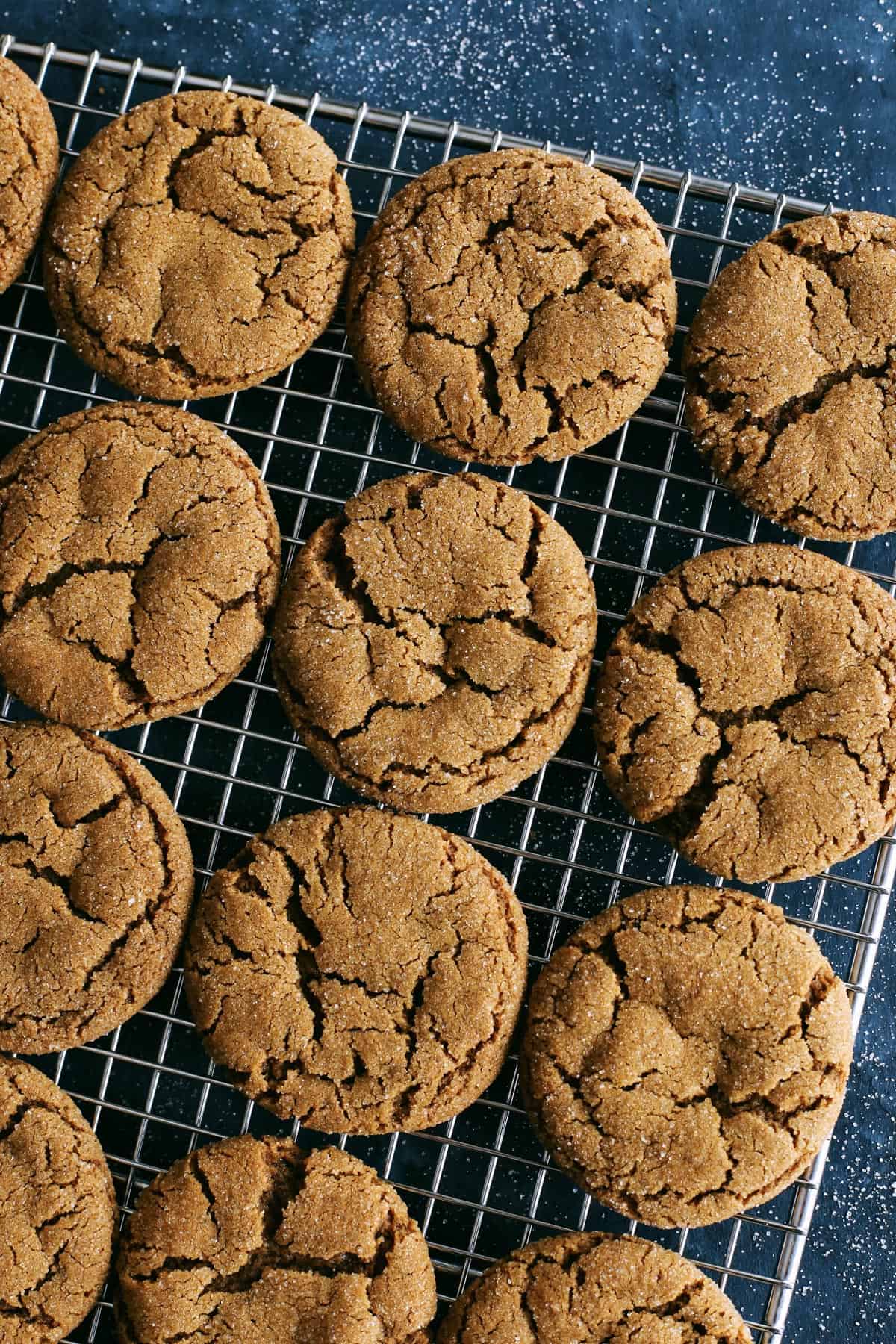 a batch of ginger molasses cookies on a cooling rack