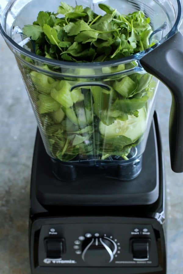 fresh green ingredients in blender pitcher