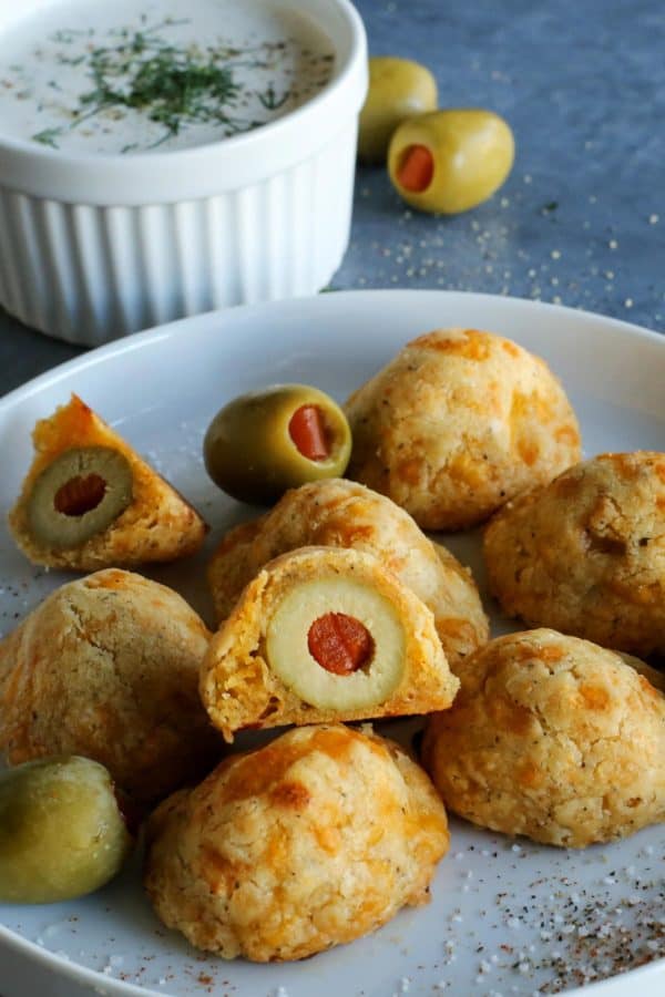 olives surrounded by cheesy dough, on a white plate