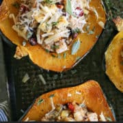 pinterest image of halved acorn squash on pan, stuffed with a turkey and dressing mixture