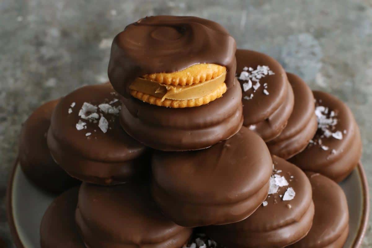 chocolate-dipped peanut butter Ritz cookies stacked on a plate