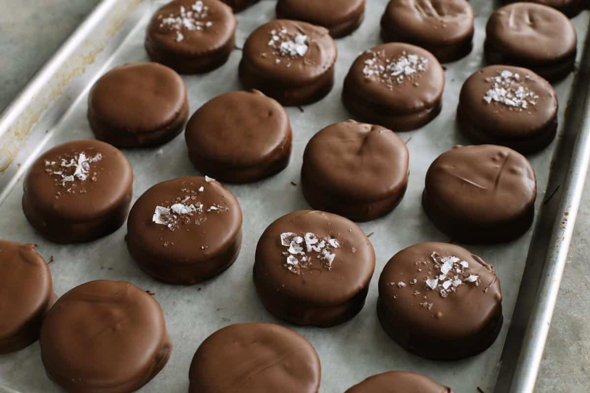 chocolate-dipped peanut butter Ritz sandwich cookies on a rimmed pan