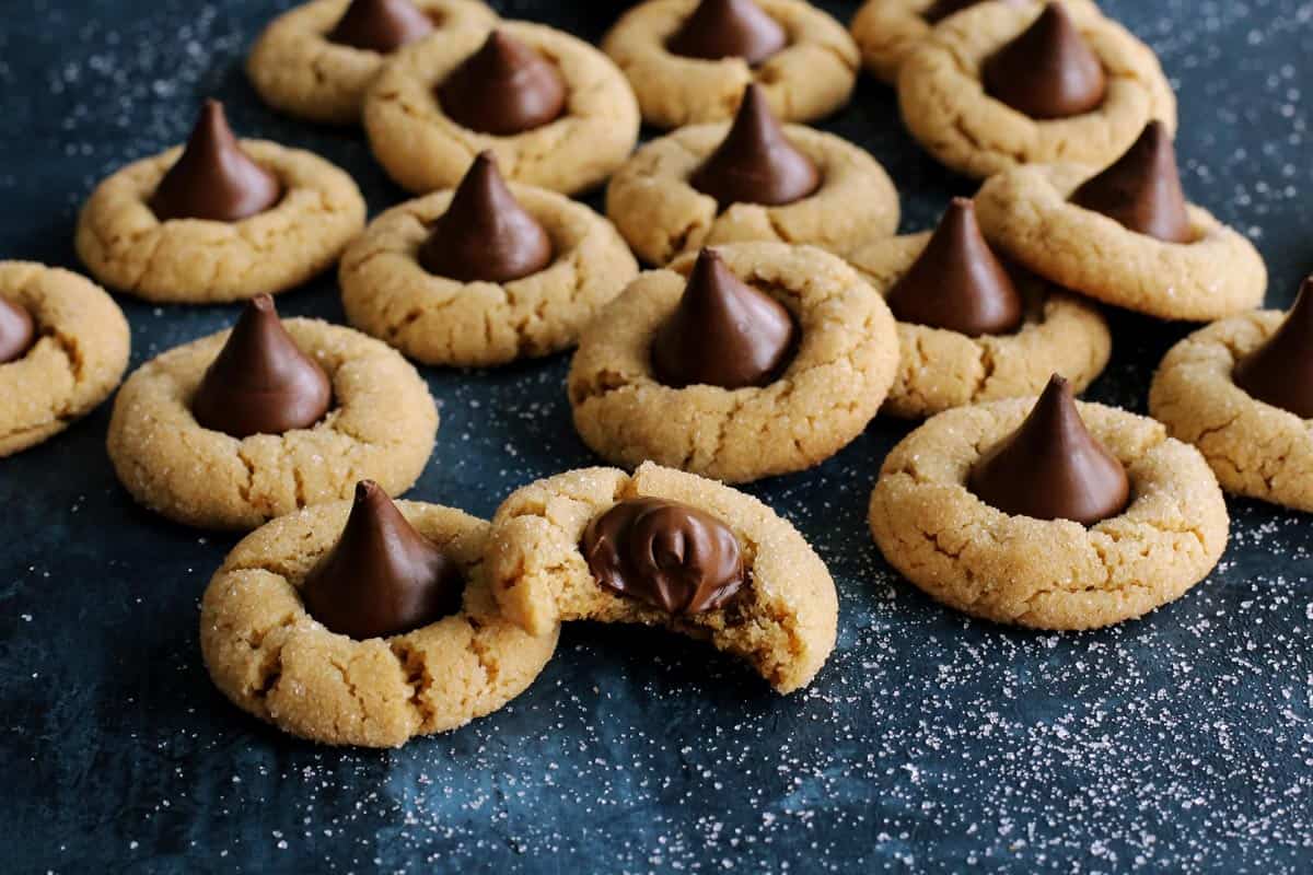 peanut butter and chocolate cookies on a blue countertop, one has a bite out of it