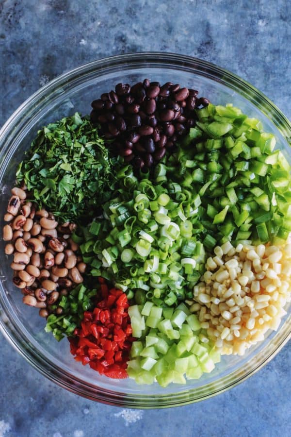 all the ingredients for cowboy caviar, separated in a clear bowl