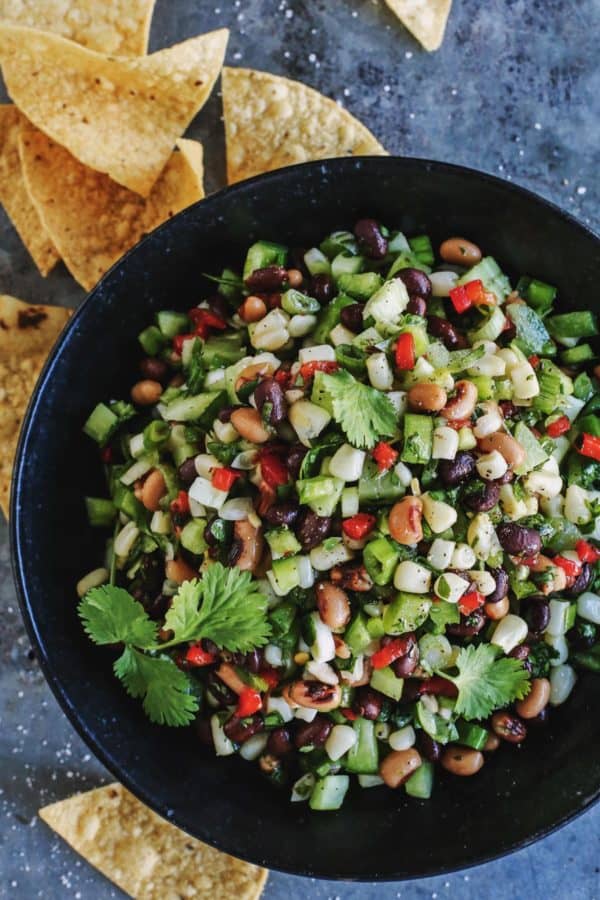 black bowl with salsa, chips on the side