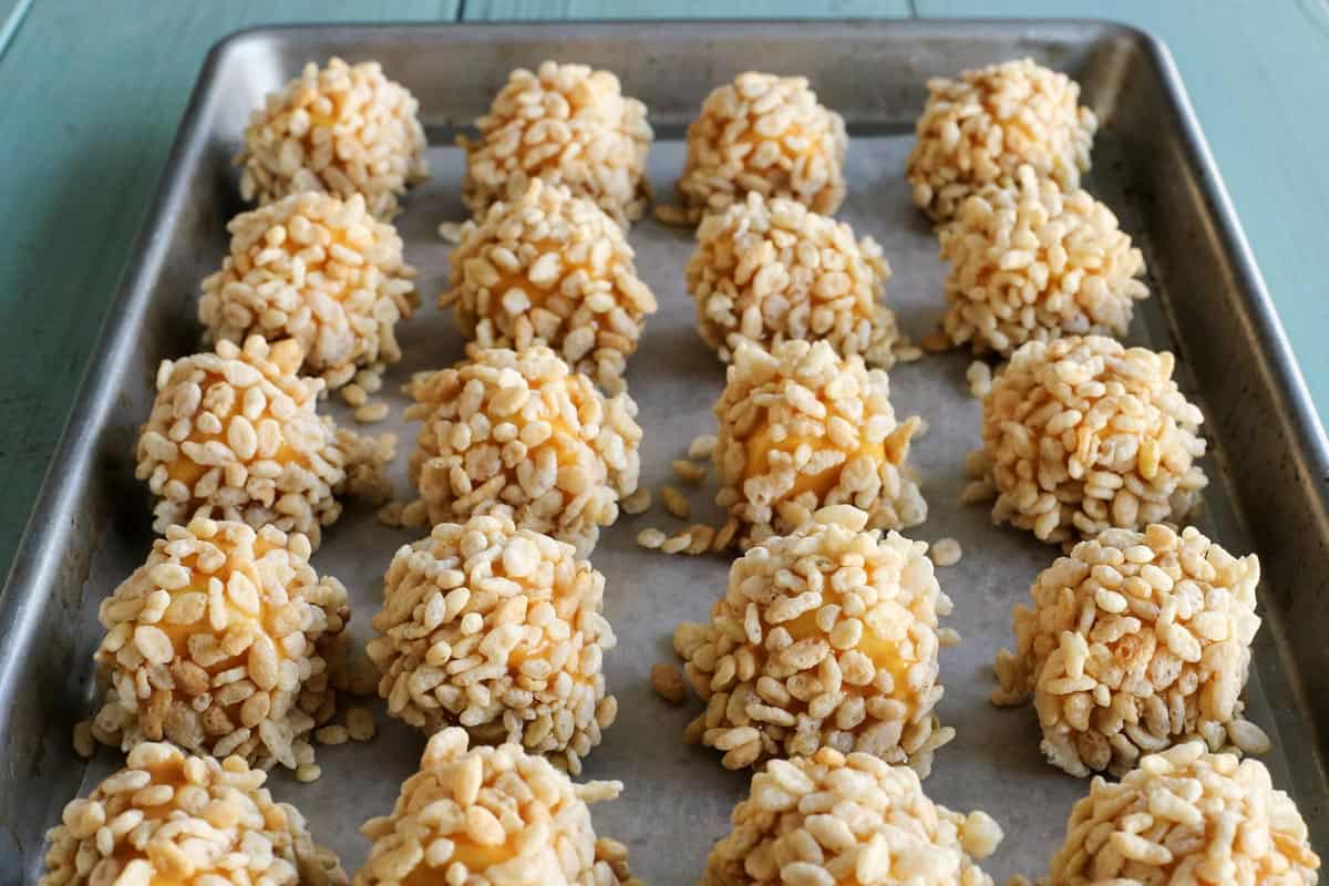 a rimmed baking pan lined with marshmallow caramel rice krispies puffs