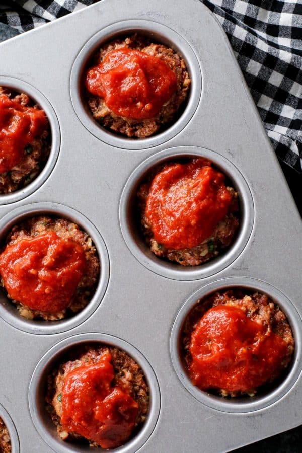 Close up shot of meatloaf muffins with marinara sauce on top