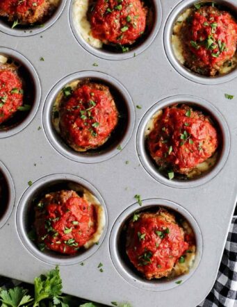 A close up shot of mini meatloaves in a muffin tin