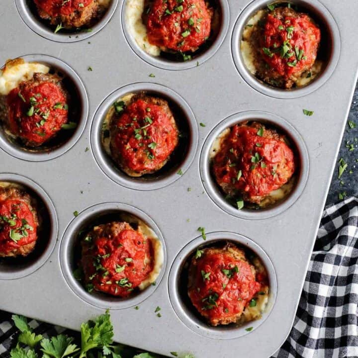 A close up shot of mini meatloaves in a muffin tin