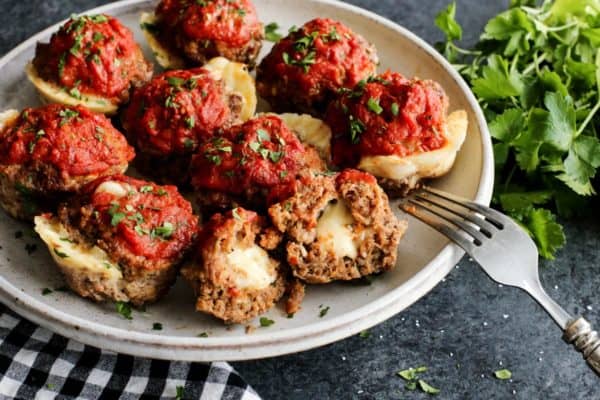 Meatloaf muffins on a plate with cheese coming out of them