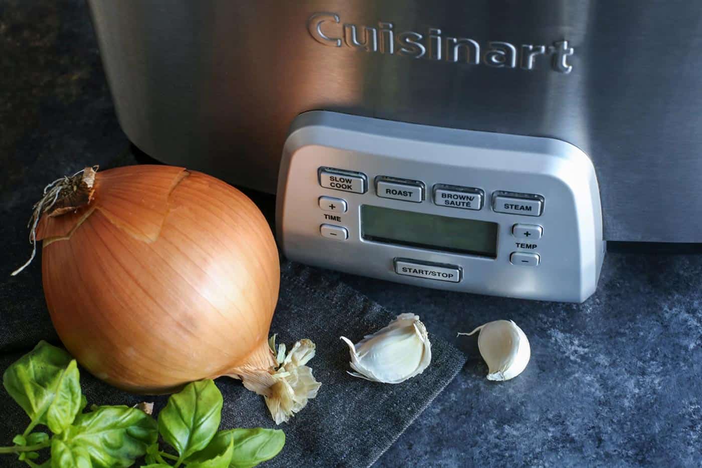 Close up photo of a crockpot with onions and garlic