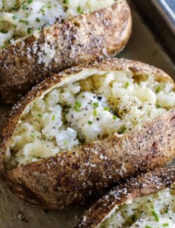 potatoes baked in the oven, split open, and topped with butter and chives