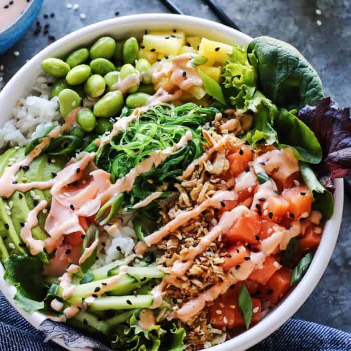 white bowl filled with poke ingredients, plus a spicy aioli